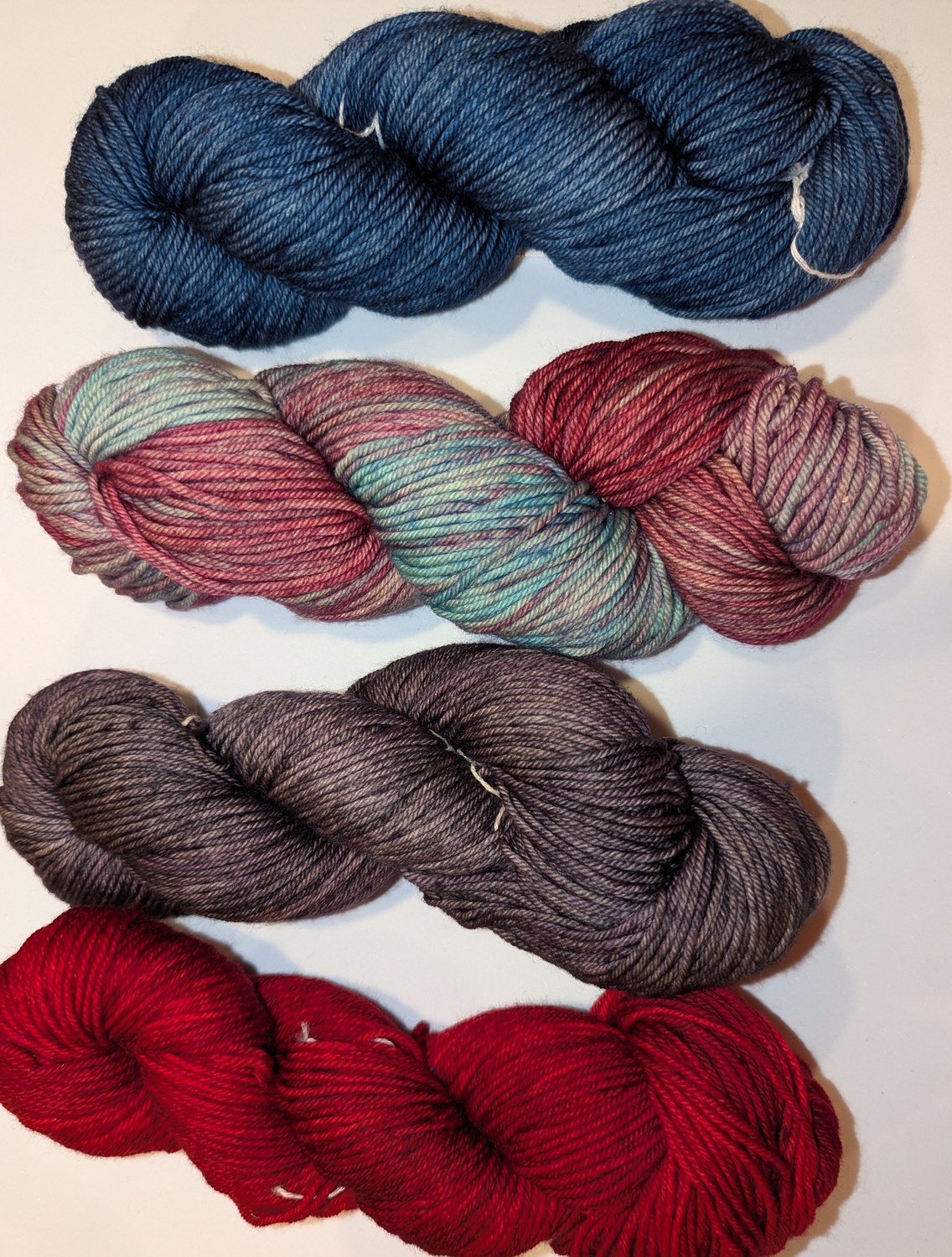Blue Jean, Cloud Sunshine, Cereza and Lotus merino wool skeins